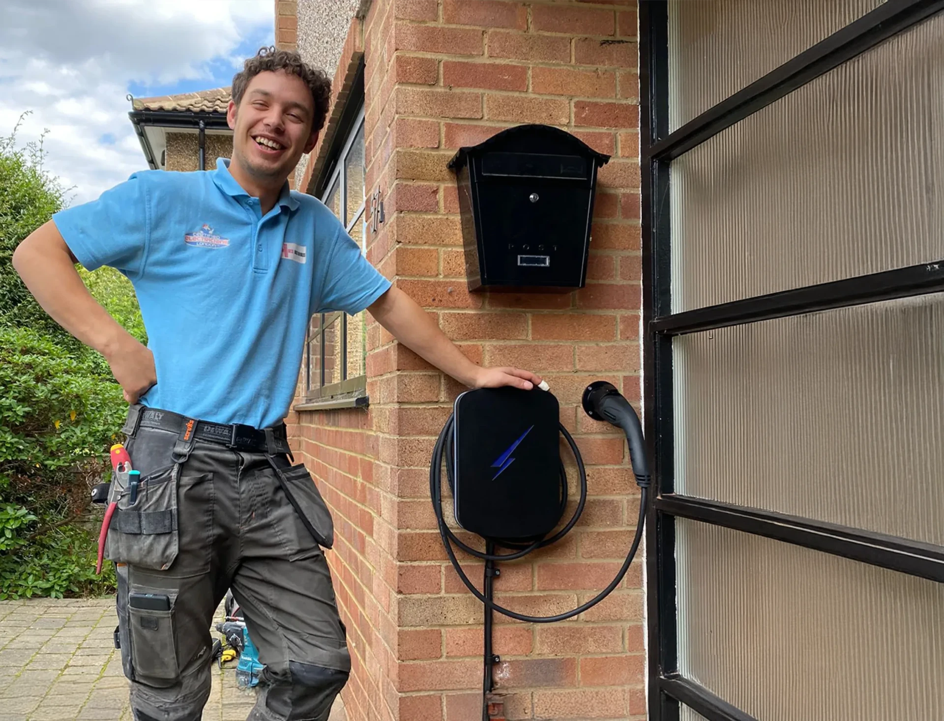 Electrician beside a newly installed home EV charger