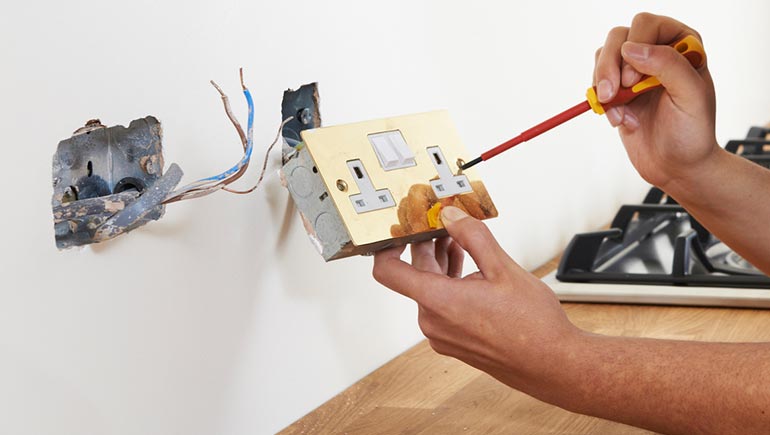 Electrician wiring a new double socket in a kitchen
