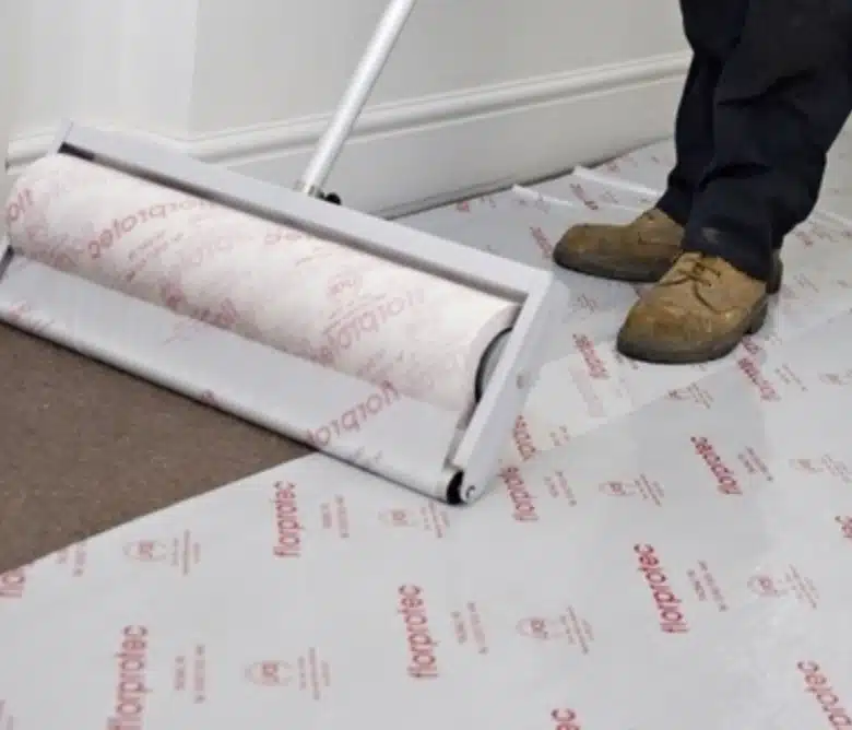 Protective film being rolled over a carpet before electrical work